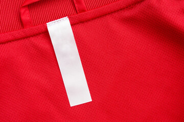 White blank clothes label on red jersey texture background