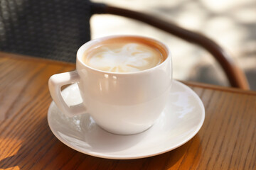Aromatic coffee on wooden table outdoors, closeup