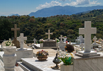 Tranquil mountain cemetery in Crete, Greece with marble tombstones