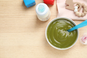 Flat lay composition with healthy baby food on wooden table, space for text