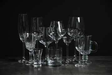 Set of bar glassware on table against dark background