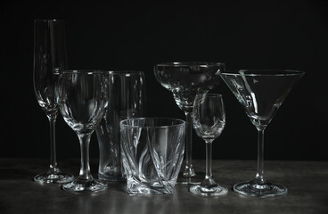 Set of bar glassware on table against dark background