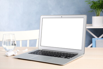 Modern laptop with blank screen on table indoors. Copy space text