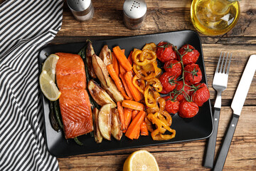 Tasty cooked salmon and vegetables served on wooden table, flat lay. Healthy meals from air fryer