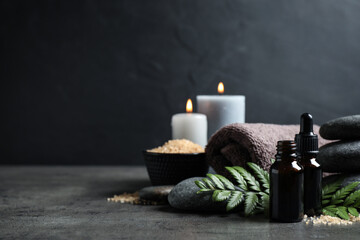 Spa composition with aroma oil on grey table, space for text