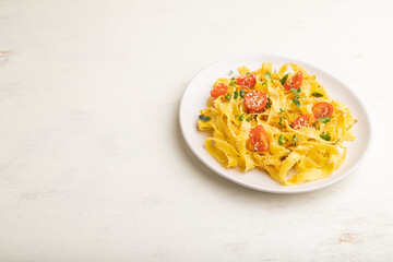 Reginelle pasta with tomato, eggs, sesame and microgreen sprouts on a white wooden background. Side view, copy space.