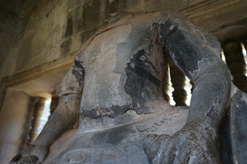 Obraz premium Broken statue without face at Angkor Wat temple in Siem Reap, Cambodia, Ancient Khmer architecture. 