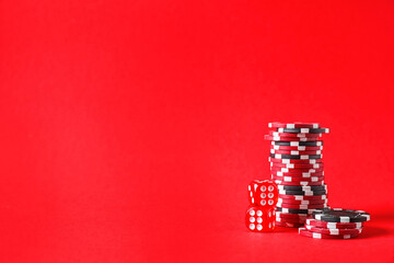 Poker chips and dices on red background, space for text
