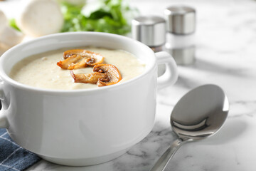 Delicious cream soup with mushrooms on white marble table, closeup