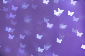 Beautiful butterfly shaped lights on purple background