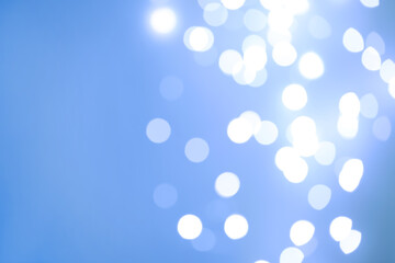 Blurred view of beautiful lights on light blue background, space for text