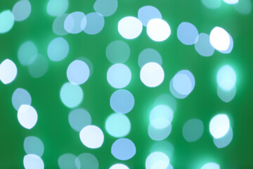 Blurred view of beautiful lights on green background