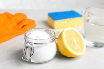 Baking soda and cut lemon on light grey table