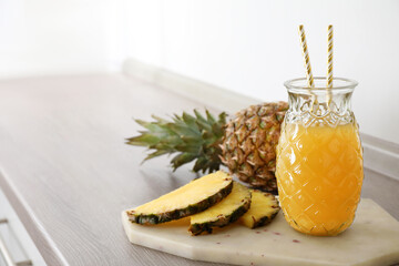 Delicious pineapple juice and fresh fruit on wooden table, space for text