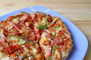 Plate of Italian Sausage with Mix Vegetables Pizza Served on Wooden Table