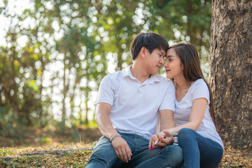 Fototapeta premium Portrait of young asian couple in love in the forest,Thailand people happy to be together,Valentine day concept