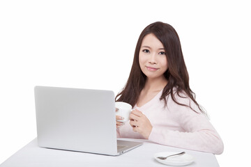 Portrait of young sitting in front of laptop holding coffee cup 