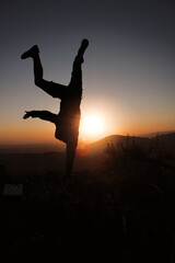 silhouette of a person jumping in the sunset