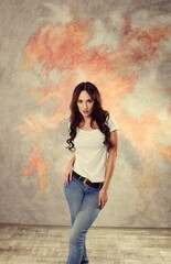 Brunette in blue jeans poses in the studio