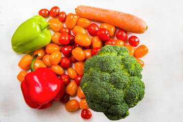 Cherry tomatoes, red and green bell pepper and broccoli on the white background