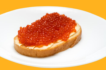Big sandwich with red caviar and butter on plate. Red salmon caviar.
