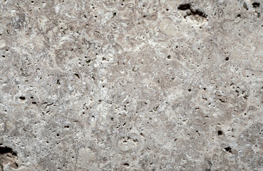 Gray stone background, macro shot. Perforated stone surface.