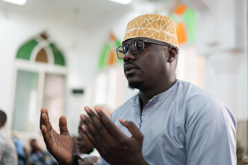 Black Muslim adult man praying inside mosque on Friday