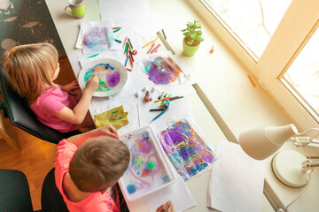 children paint with watercolors at home. creative young artist at work