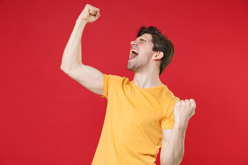 Young excited happy overjoyed gladden unshaved man in casual basic yellow t-shirt doing winner...