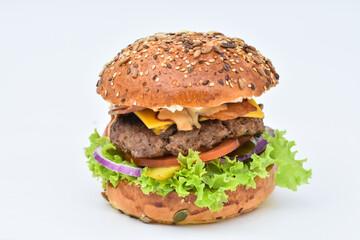 burger with melted cheese, ham, tomatoes and fried onions