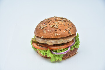 burger with melted cheese, ham, tomatoes and fried onions