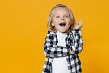 Little cute fun happy blond long-haired kid boy 5 years old wearing casual clothes posing isolated on bright yellow wall color background children studio portrait. People childhood lifestyle concept
