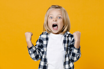 Little naughty fun blond long-haired kid boy 5 years old wearing casual clothes screaming isolated on bright yellow wall color background children studio portrait. People childhood lifestyle concept