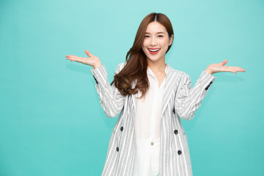 Happy Asian woman presenting or showing open hand palm with copy space for product isolated over green background