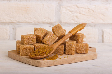 Reed Sahao in cubes on a wooden board and a spoonful of sugar with sand