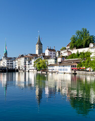 Fototapeta na wymiar Limnat River Cityview in Zurich, Switzerland showing the Church of St Peter spire in Summer
