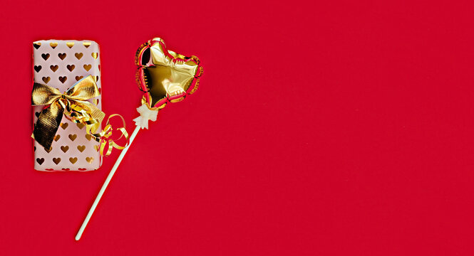 Golden balloon souvenir heart, gift isolated on red background. Helium balloons, gold foil numbers. Numbers for Valentine's day. Party decoration, celebration, carnival.