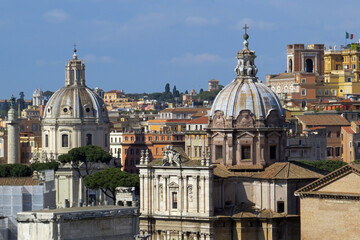 Fototapeta na wymiar View of the roofs of the Churches of Nome di Maria or The Church of the Most Holy Name of Mary and San Maria di Loreto and Trajan's Column at the Trajan Forum in front of the capitol in Rome, Italy