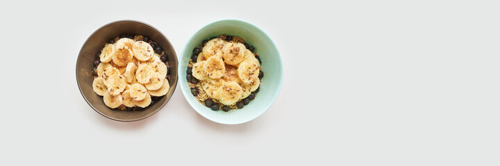 Healthy breakfast. Top view. Oatmeal with banana and flax seeds at bowl. Berry in plate. Organic meal recipe. Vegan cook. Minimalism granola. Hot porrigde with fruit. Banner, copyspace