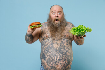 Shocked fat pudge obese chubby overweight man has tattooed naked bare big belly hold fast food...