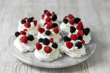 Pavlova cake. The cakes are on a marble platter. Sweet Dessert. A treat for guests. Dessert for the holiday. Cake decorated with berries.
