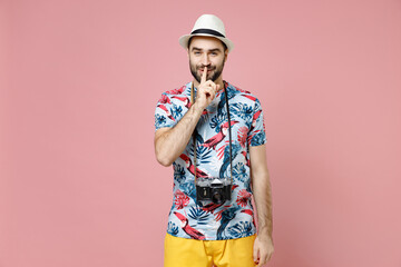 Secret traveler tourist man in summer clothes hat photo camera say hush quiet with finger on lips shhh gesture isolated on pink background. Passenger traveling on weekends. Air flight journey concept.