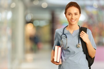 Attractive young female doctor with blurred hospital interior on background