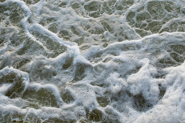 Foamy water surface in the river. Dirty water in a pond. Foamy wave