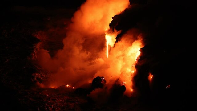 Hawaii Lava ocean - flowing lava reaches ocean on volcanic eruption on Big Island, Hawaii. Lava stream flowing from Puu Oo, Kilauea volcano by Hawaii volcanoes national park, USA. Night shot 59.94 FPS