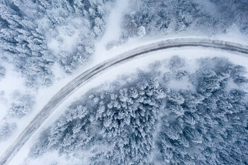 Snow lane curve of a country road through a snowy forest in winter