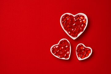 Three small heart-shaped plate with small hearts inside. Valentines day concept or postcard. Holiday symbol. Space for text. Top view.