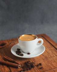Cup of coffee and coffee beans on wooden board with copy space.  Vertical photo