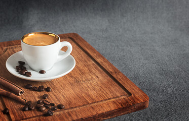 Cup of coffee and coffee beans on wooden board with copy space