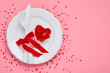 Valentines day background or concept with empty white plate and cutlery fork and knife with red ribbon on pink background. Concept or postcard. Top view flat lay with copy space.